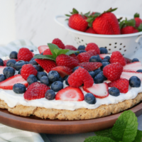 Dessert pizza topped with fresh berries over a whipped cream base.