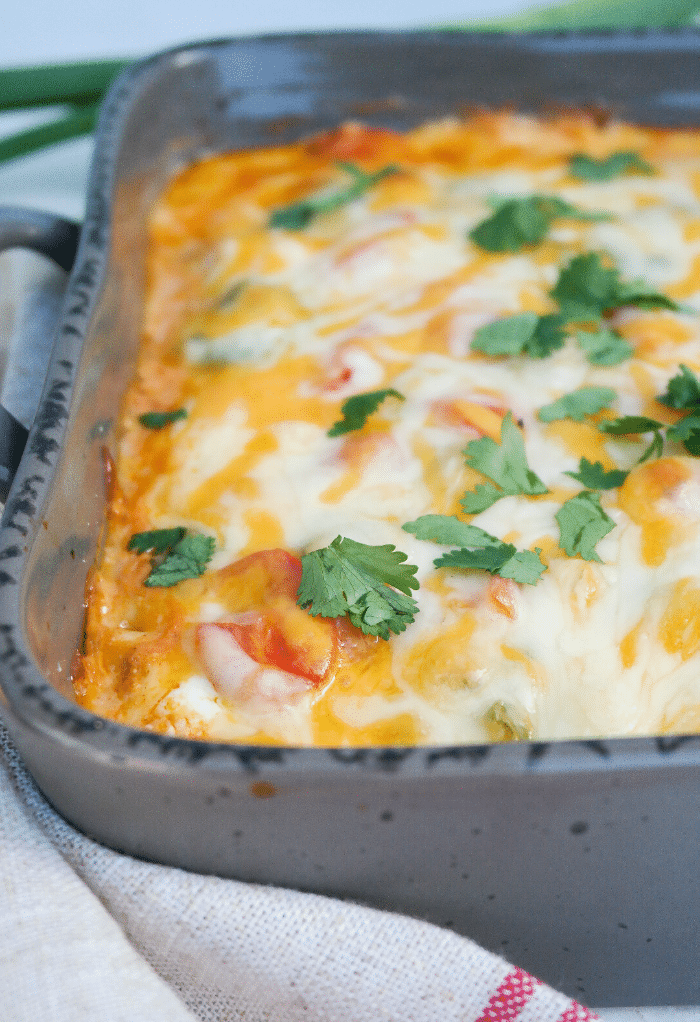 Casserole dish with melted cheese on top with fresh cilantro. 