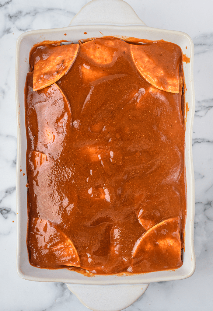 Layered casserole with red enchilada sauce.