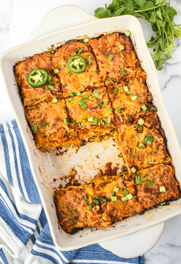 Top view of sliced enchilada casserole ready to serve in individual plates.