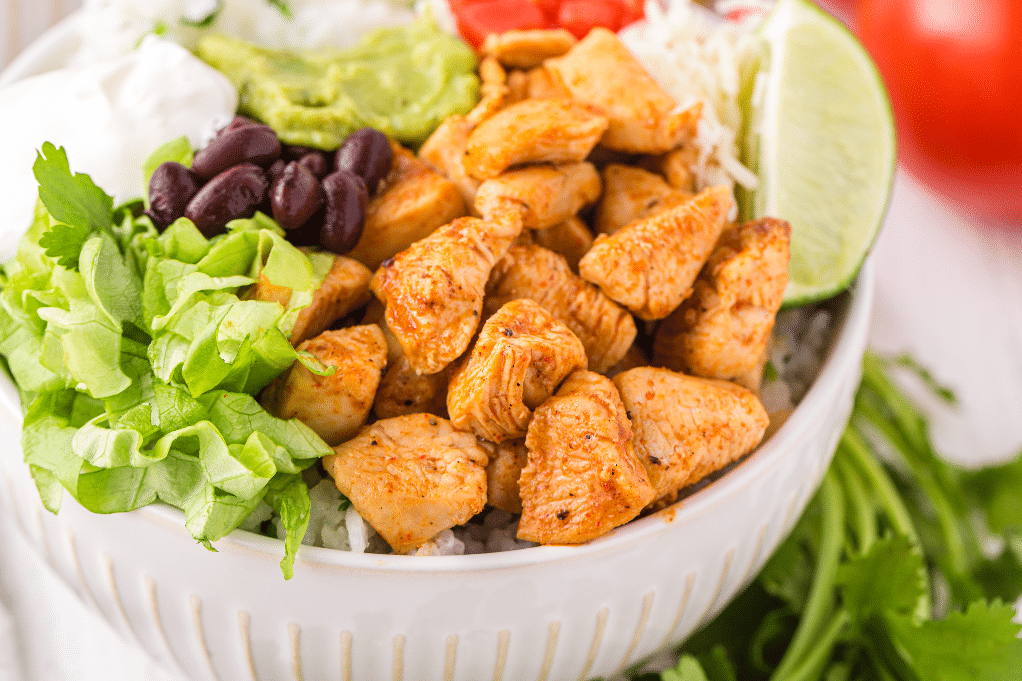 Chipotle chicken bowl with lettuce beans topped with lime.  