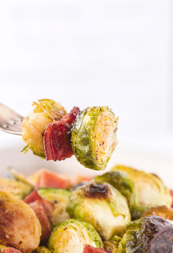 A forkful of cooked bacon and Brussels sprouts.