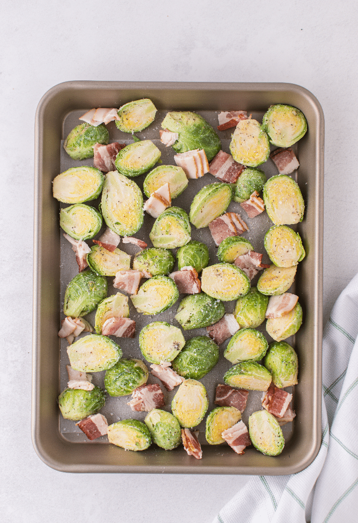 Fresh Brussels sprouts on a baking sheet ready to roast in the oven. 