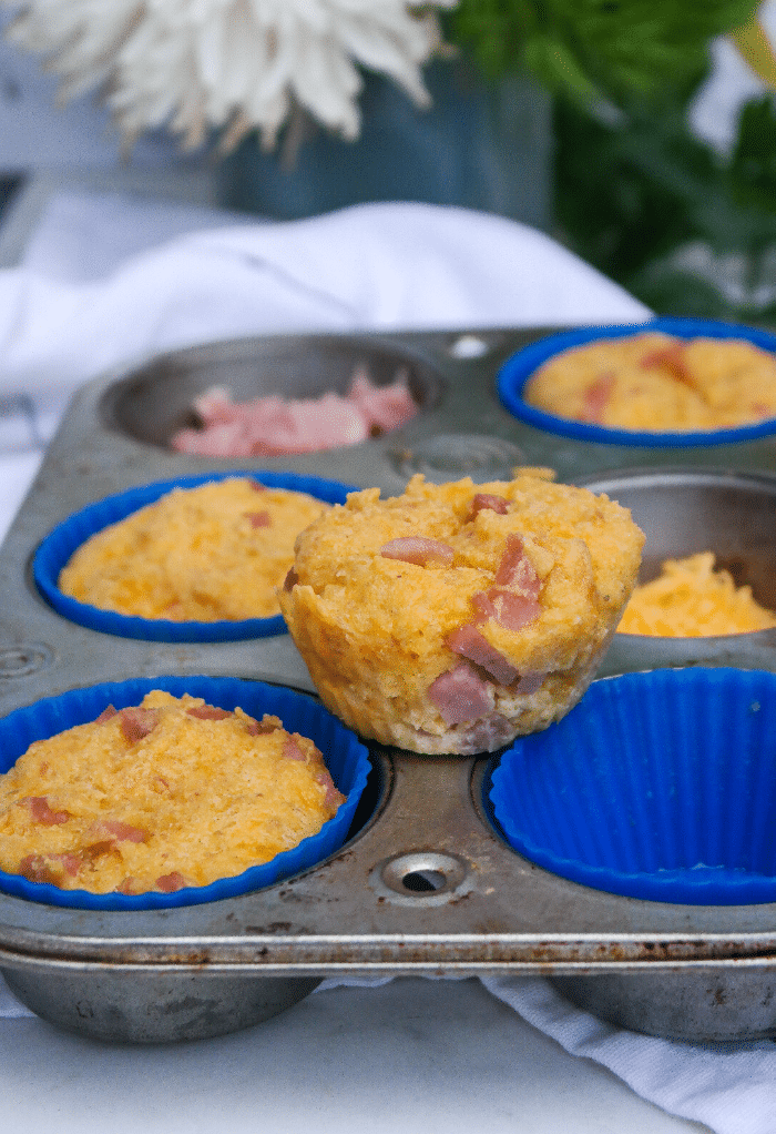 Baked keto muffins in a muffin tin with blue silicone lines. 