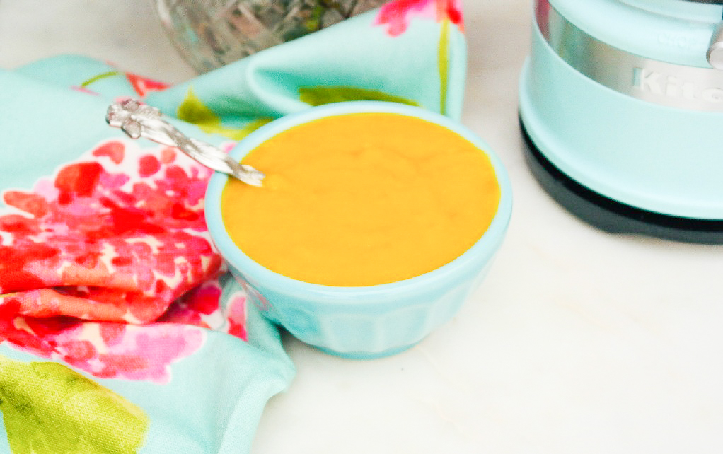 Homemade mango puree in a teal bowl ready to use.