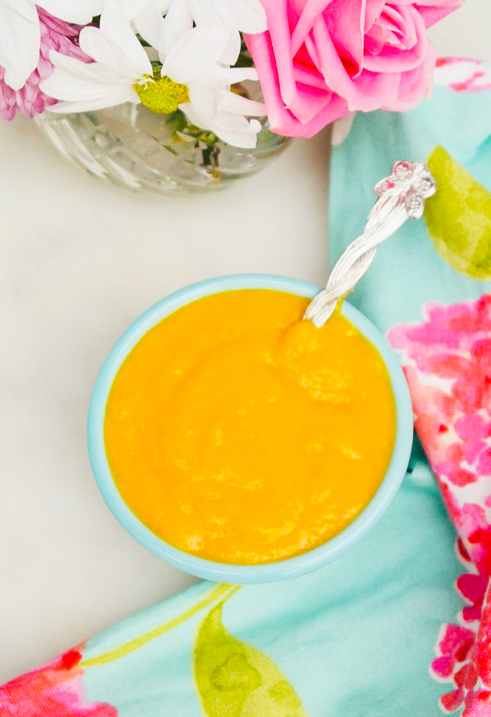 Top view of mango in a bowl with a teal napkin with bright pink flowers on it. 