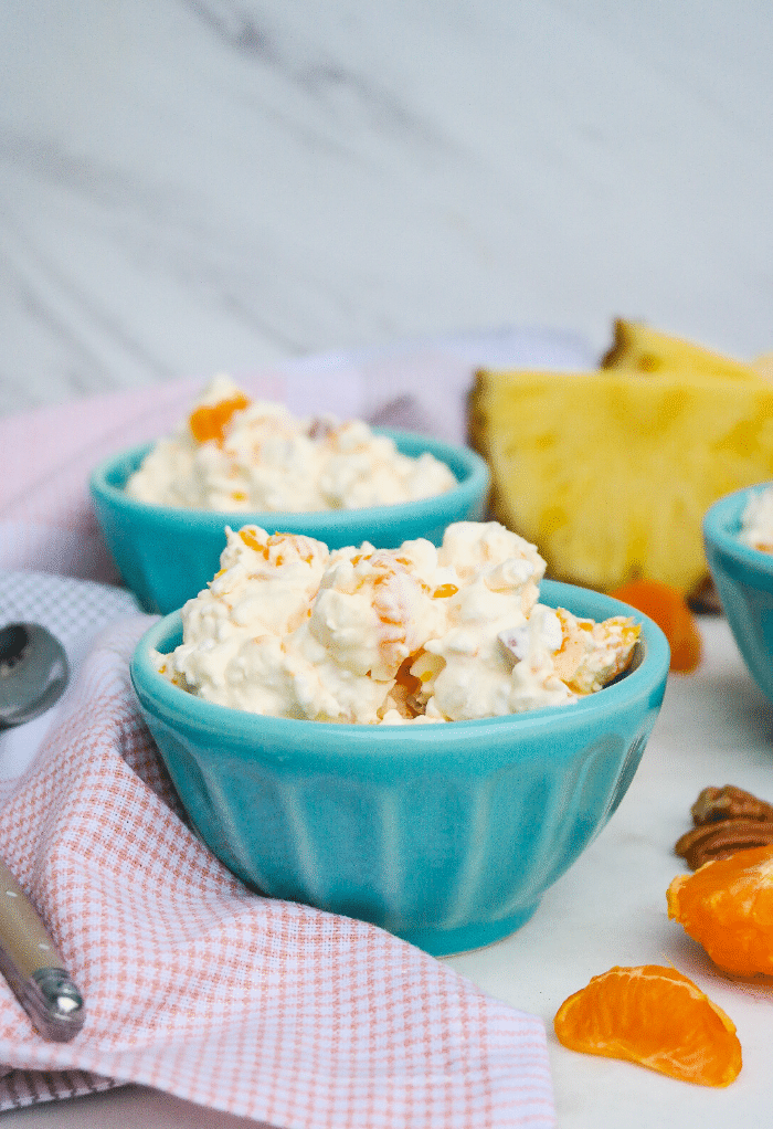 Teal small bowls filled with orange jello salad.