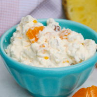 A small teal bowl with sugar free orange salad with fruit ready to eat.