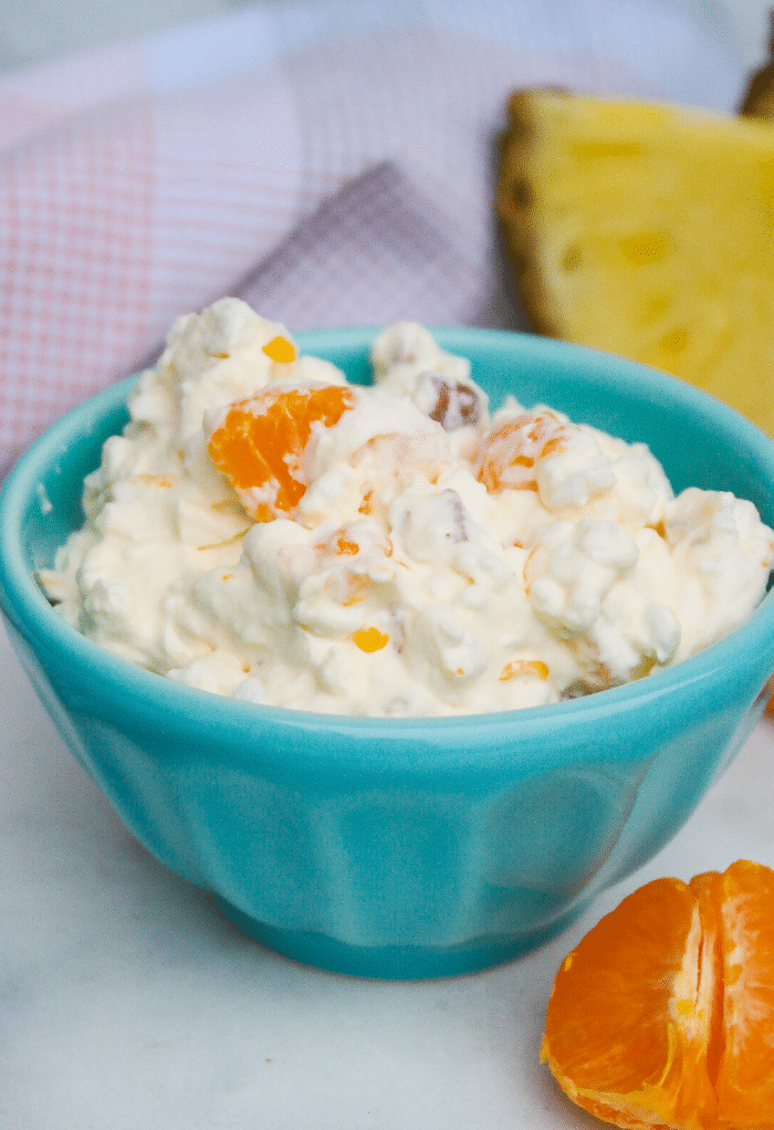 A small teal bowl with sugar free orange salad with fruit ready to eat. 