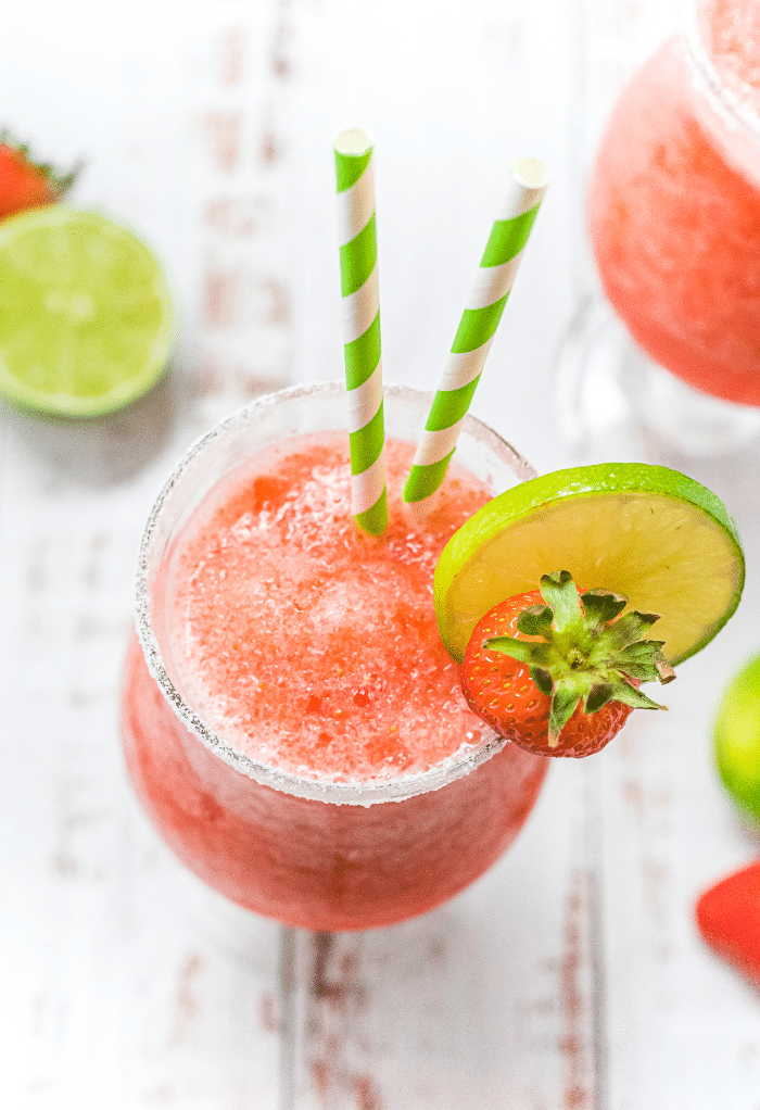 Top view of a virgin strawberry daiquiri with green straws. 