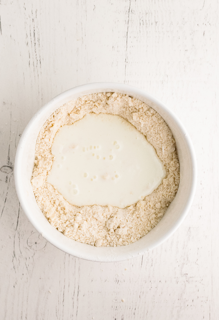 Buttermilk in the center of flour mixture for biscuits.