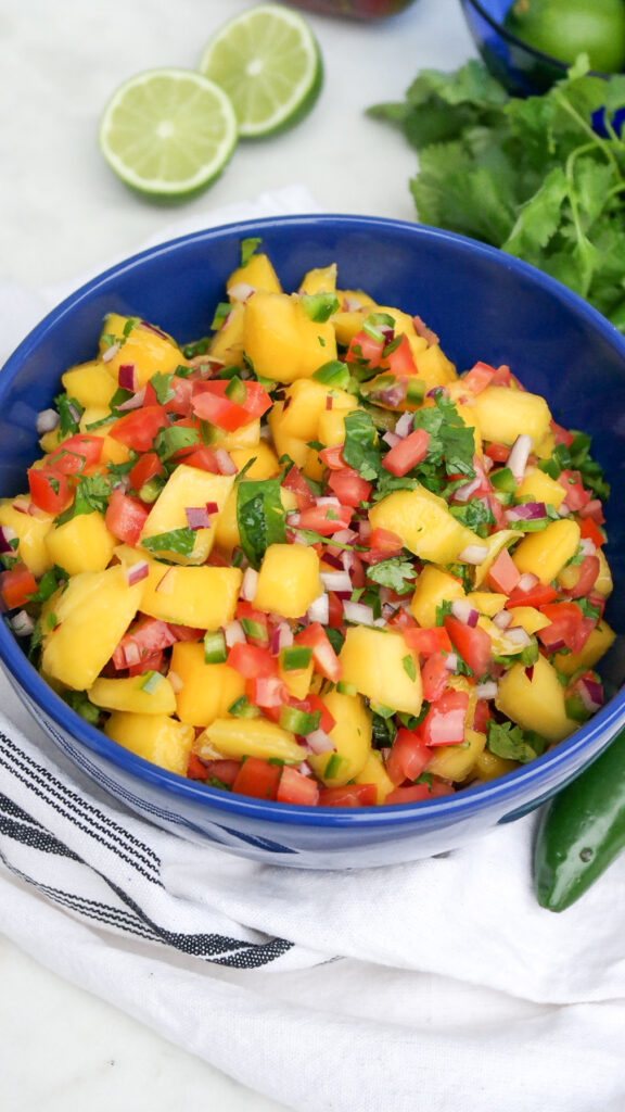 All ingredients mixed in a blue bowl for pico de gallo. 