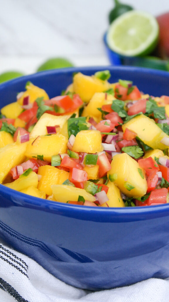 Fresh fruit salsa with mangos in a blue serving bow.