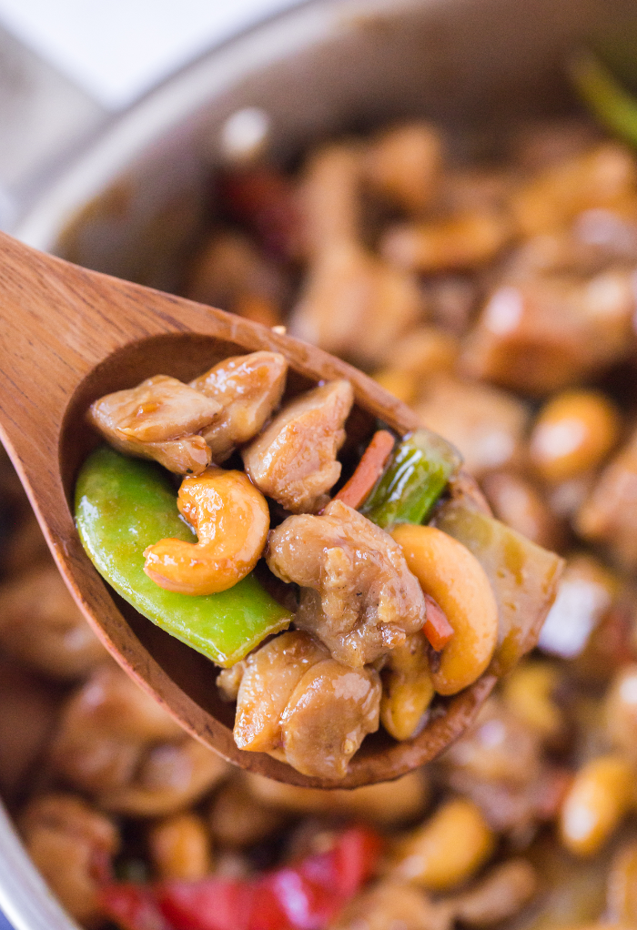 A wooden spoon with teriyaki chicken stir fry.