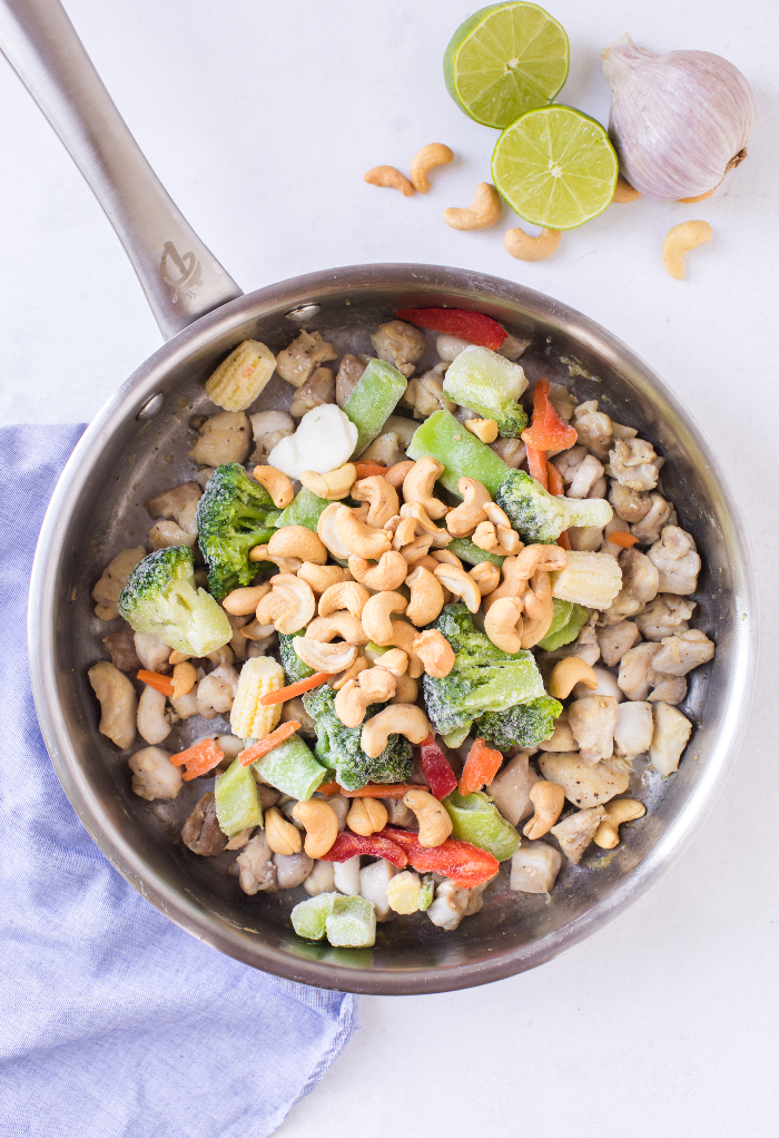 Vegetables with the chicken in a skillet. 