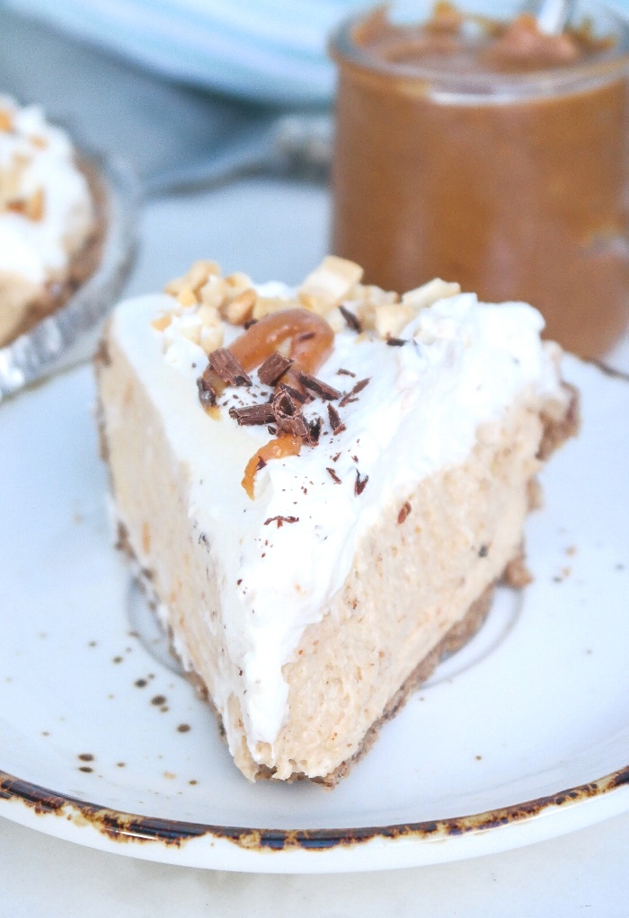 A slice of peanut butter pie on a white plate with a brown rim.