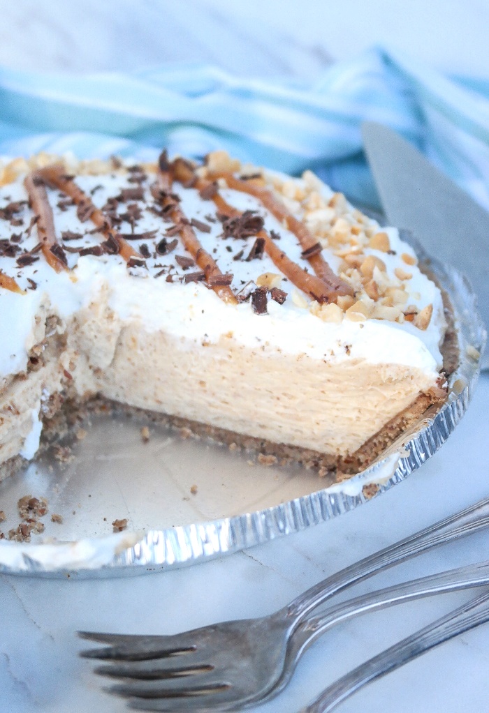 A peanut butter pie with a couple of slices taken out.