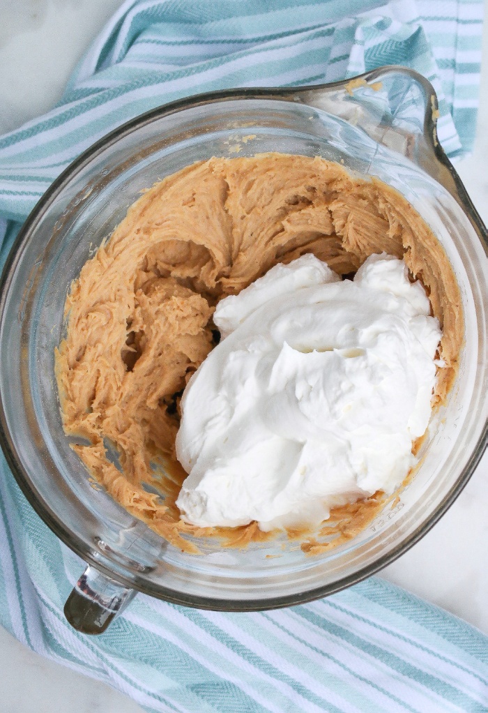 Fresh whipped cream added to peanut butter pie filling.