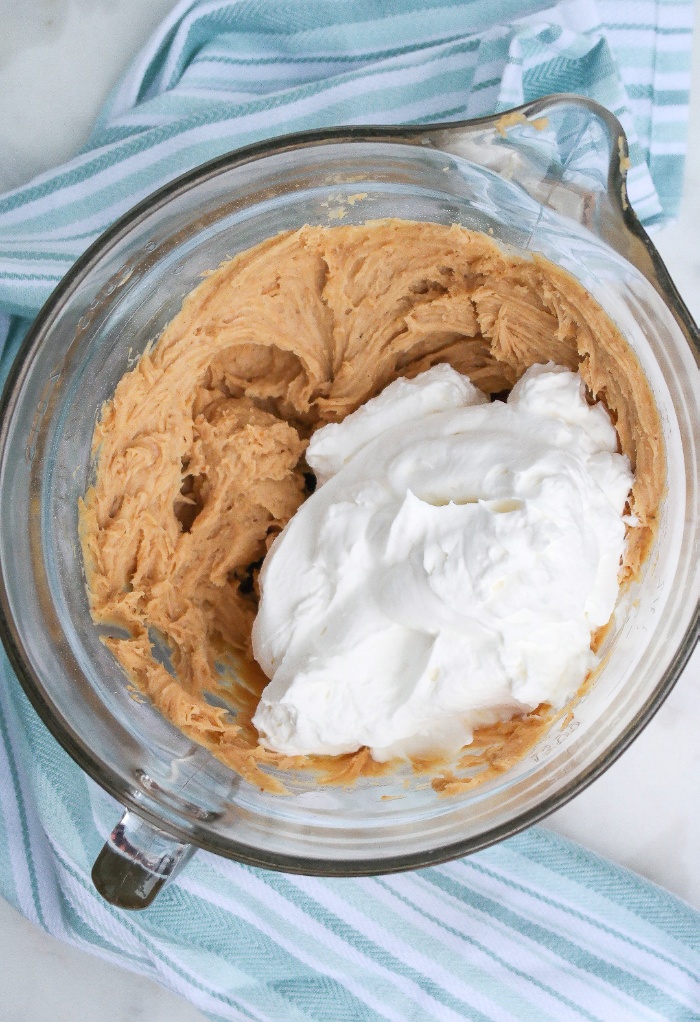 Fresh whipped cream added to peanut butter pie filling.