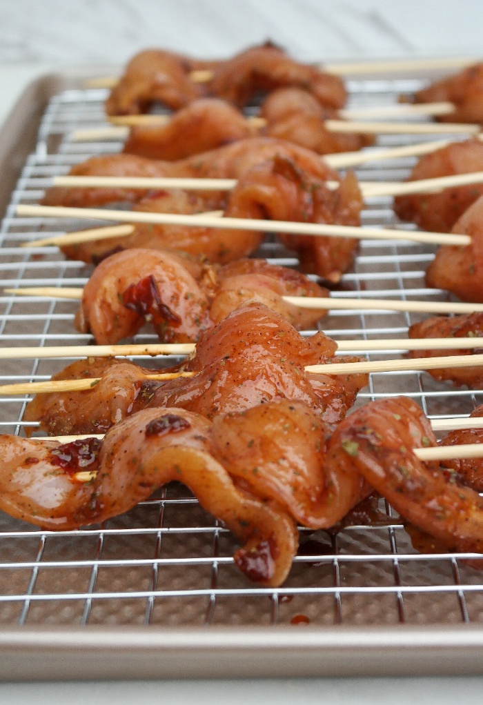 Chicken skewers on a baking sheet.