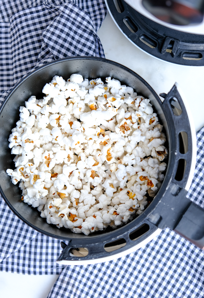 Popped popcorn in the basket of an air fryer.