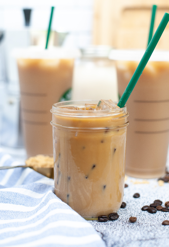 Clear Mason jar with brown sugar oat milk espresso beverage.