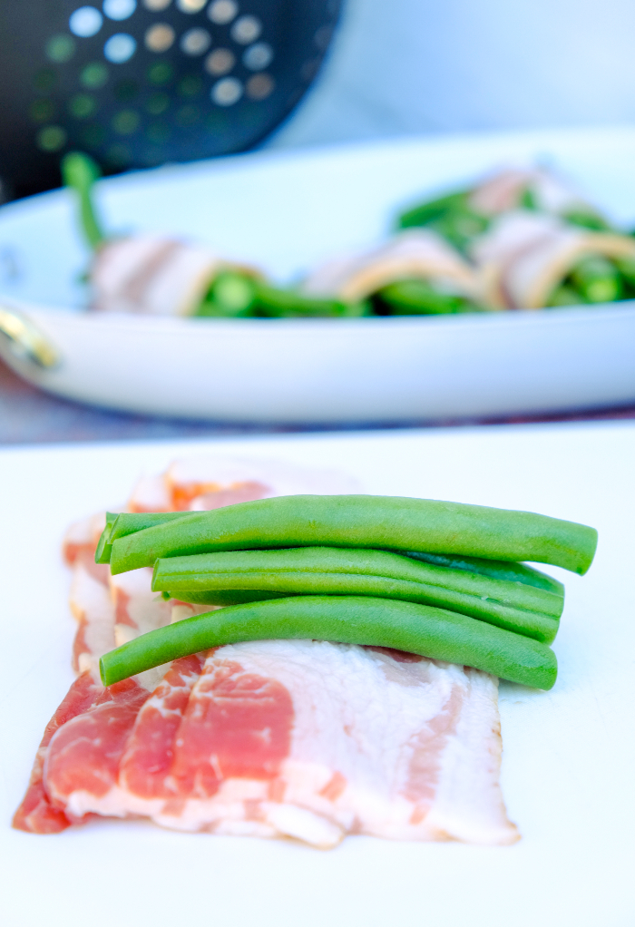 Fresh green beans placed on a slice of bacon.