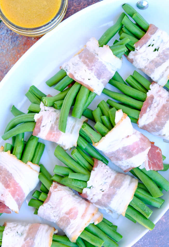 Bacon wrapped green beans on a baking pan. 