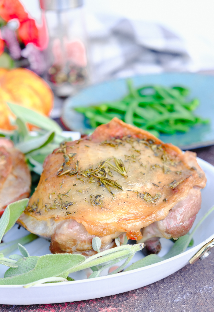 Roasted turkey thigh on a white plate ready to eat. 