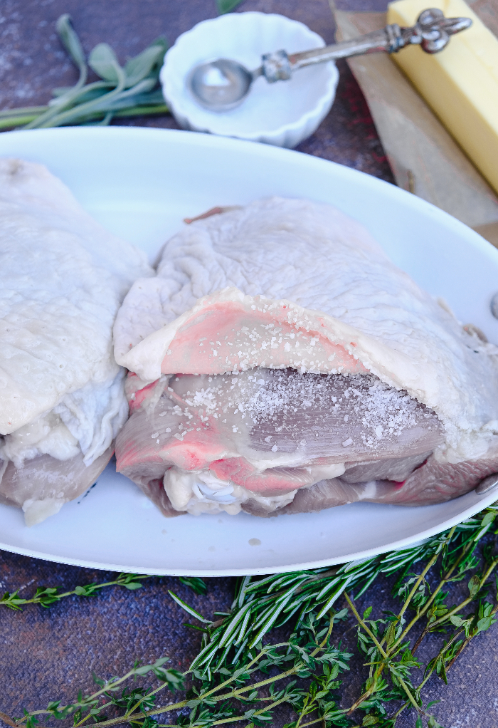 Salted turkey thighs before roasting in the oven.