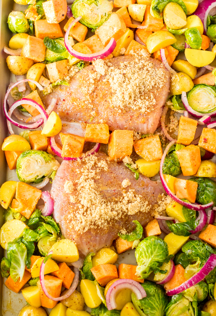 Vegetables and turkey tenderloin on a baking sheet ready to roast.