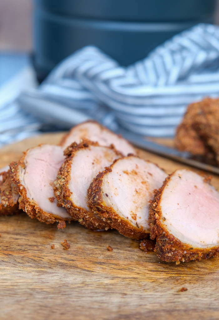 Sliced pork tenderloin on a cutting board. 