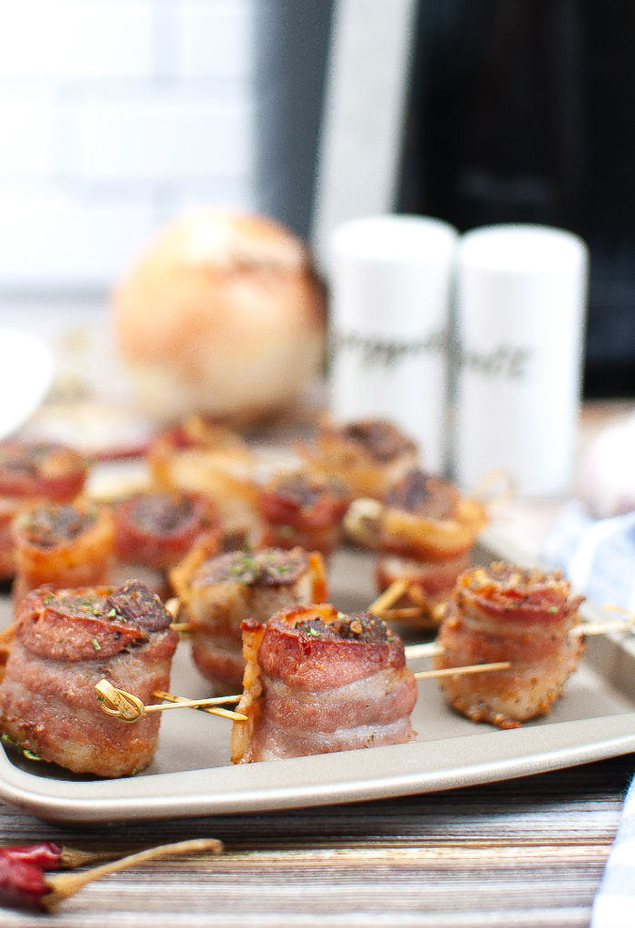 Steak bites wrapped in bacon on a baking pan ready to eat. 