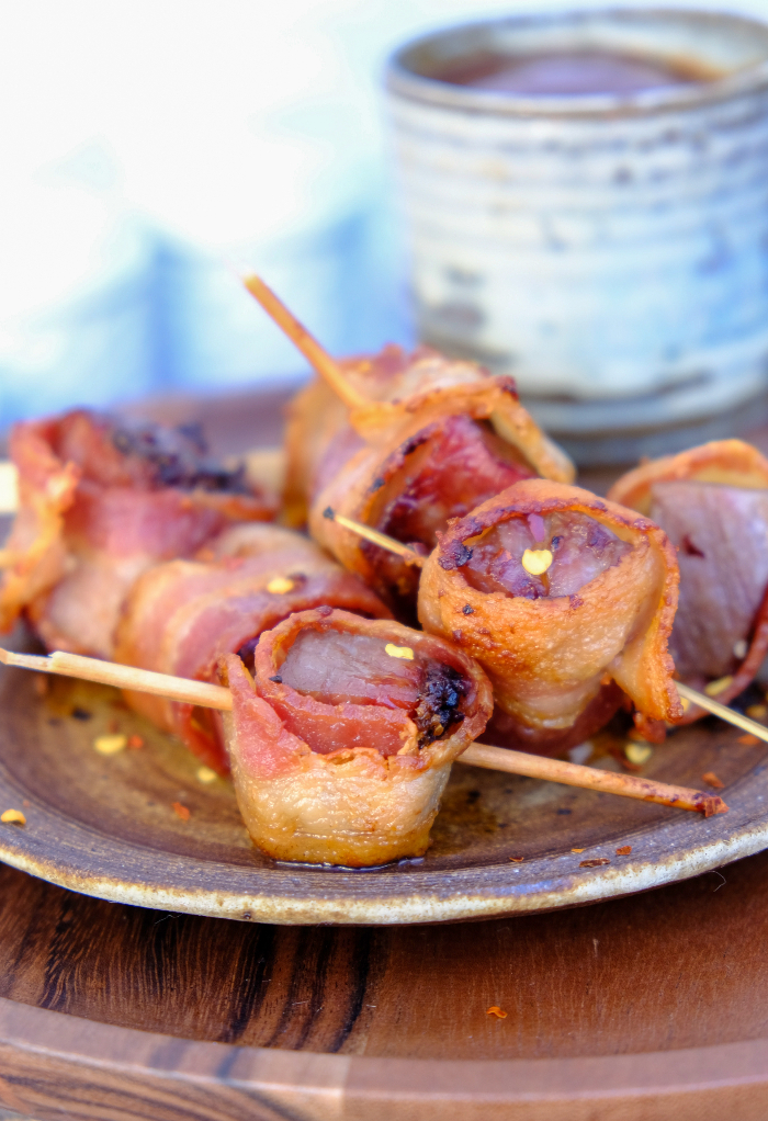 Easy appetizer steak with bacon on a brown serving plate.