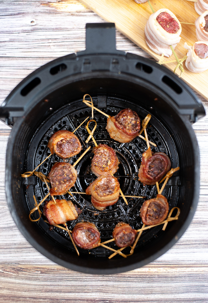 Cooked air fryer steak bites wrapped in bacon.