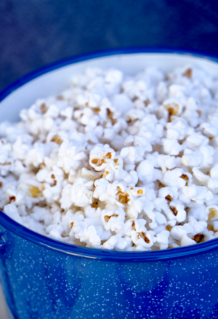 Fresh stovetop popcorn in a blue pan.