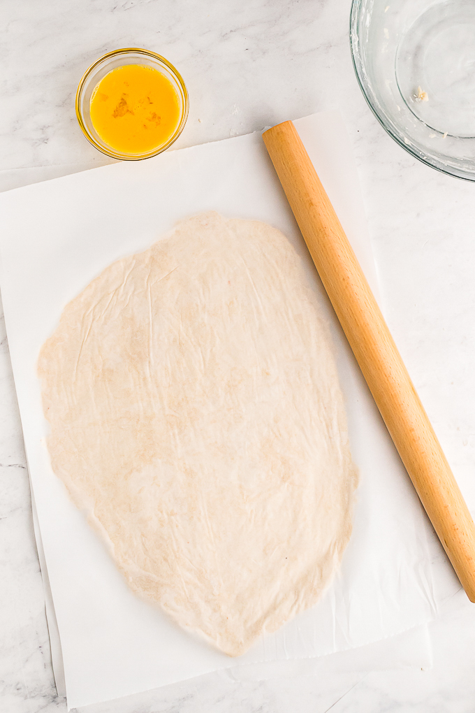 Galette dough rolled between parchment paper.