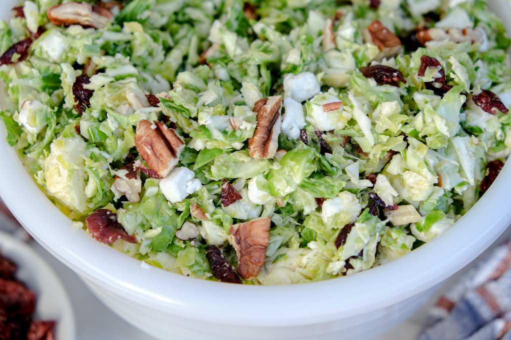 Brussel sprout salad in a white serving bowl.