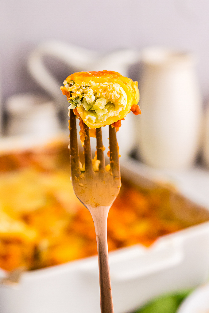 A forkful of cheesy manicotti ready to eat. 