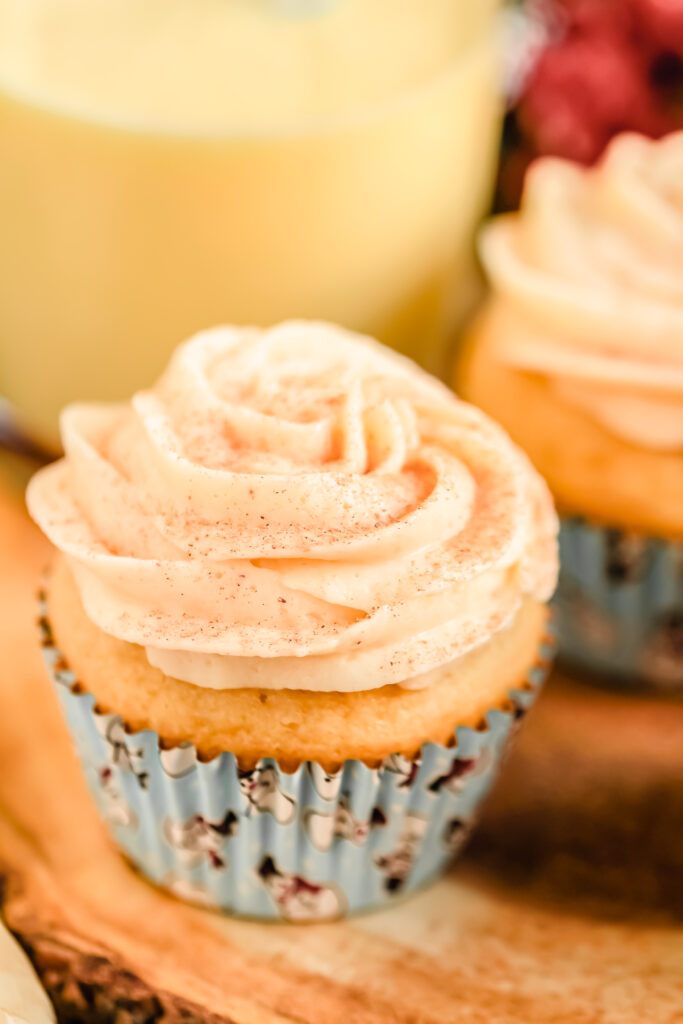 Eggnog cupcakes on a wooden stand.