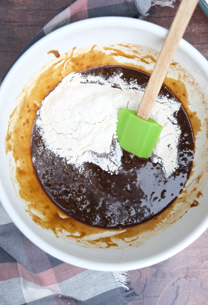 Wet and dry ingredients for gingersnap cookies in a mixing bowl. 