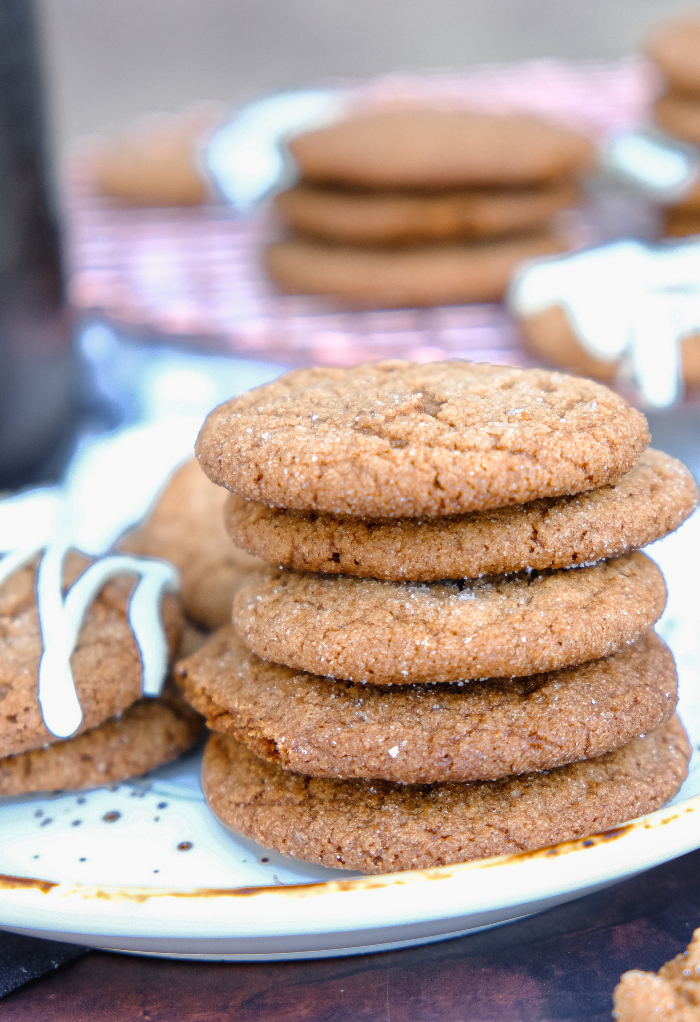 A stack of gingersnap cookies on a white plate ready to eat.