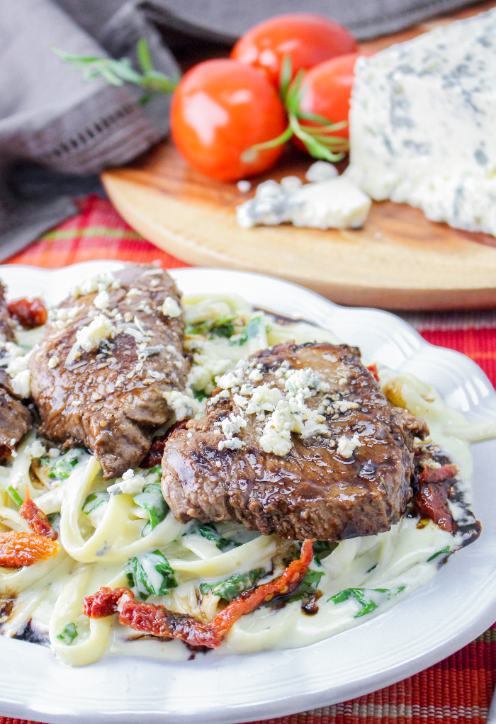 Copycat Olive Garden Steak Gorgonzola Alfredo dish on a white serving plate.