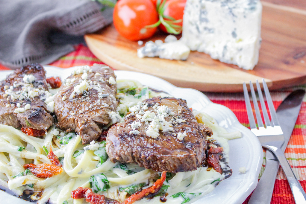 Copycat Olive Garden Recipe with steak and pasta on a serving dish.