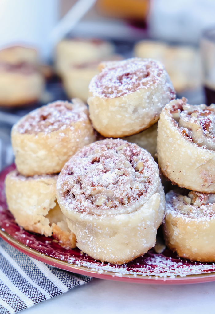 A maroon plate topped with pie crust cookies on top of each other. 