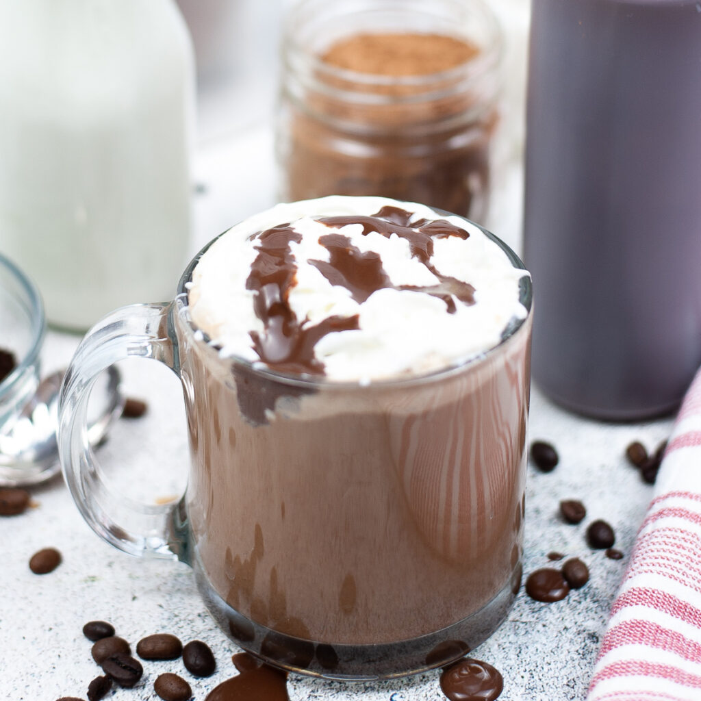 Copycat Starbucks skinny mocha espresso beverage topped with whipped cream and a drizzle of chocolate.