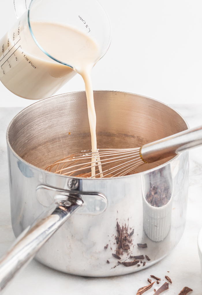 Adding oat milk to chocolate pudding mix. 