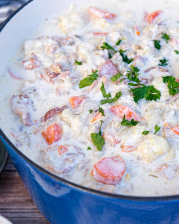 Keto clam chowder recipe cooked and simmering in a blue Dutch oven.