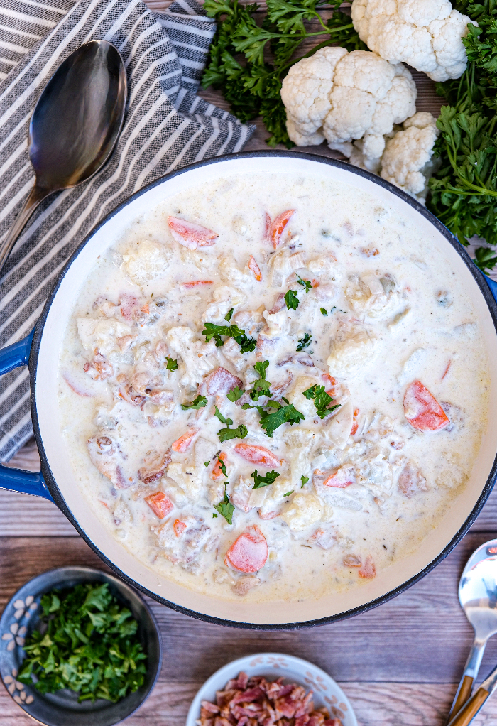 Top view of clam chowder with bacon and parsley on the side. 