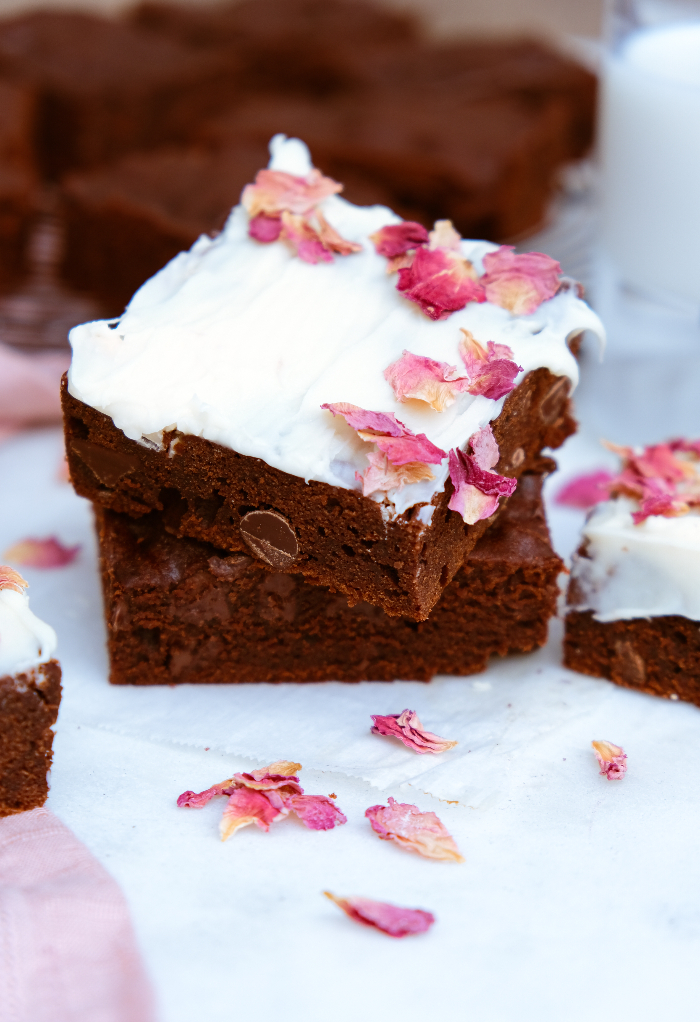 Brownies topped with white chocolate and rose petals.